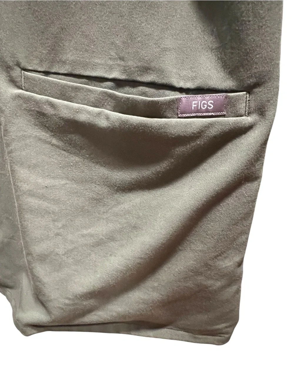 FIGS Casma three-pocket V-neck scrub top featuring a soft greyish-green.